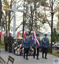 poczet sztandarowy składający się z trzech policjantów na tle pomnika żołnierza Polskiego